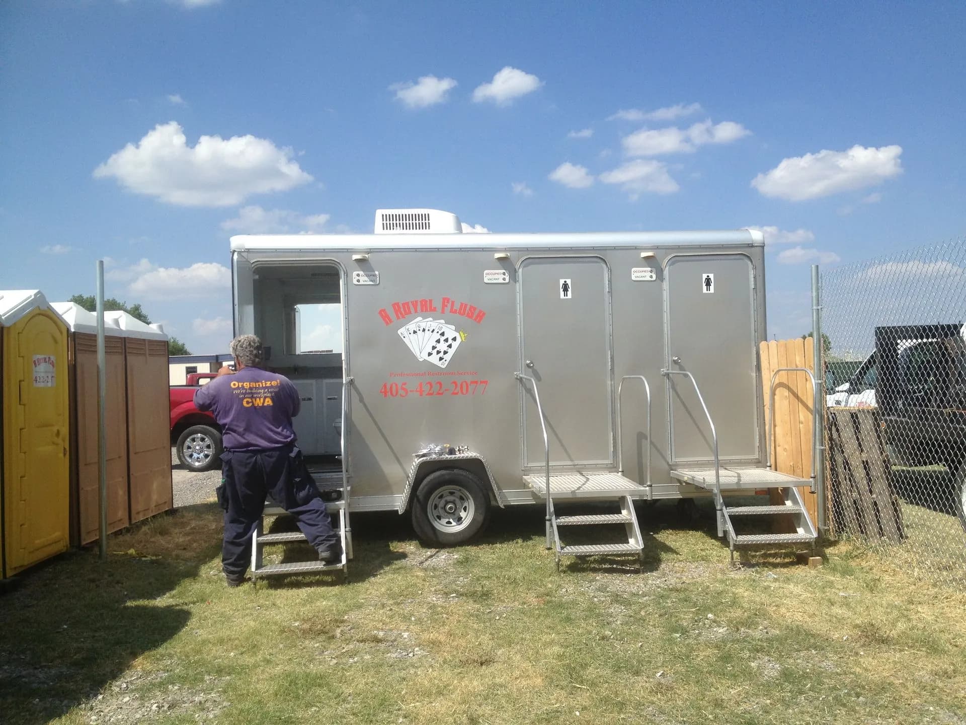 An A Royal Flush restroom trailer with flushing toilets set up for an outdoor event
