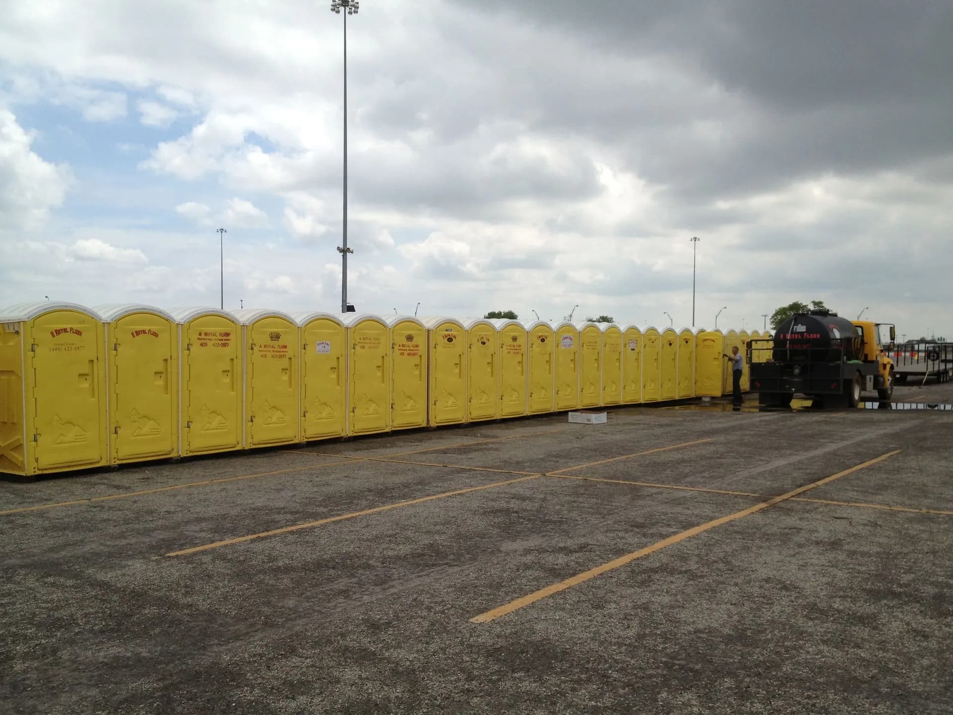 A long row of A Royal Flush yellow portable toilets lined up at an Oklahoma City event