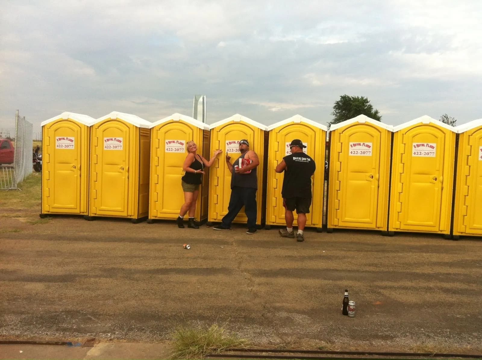 The A Royal Flush crew setting a row of yellow portable toilets on a job site