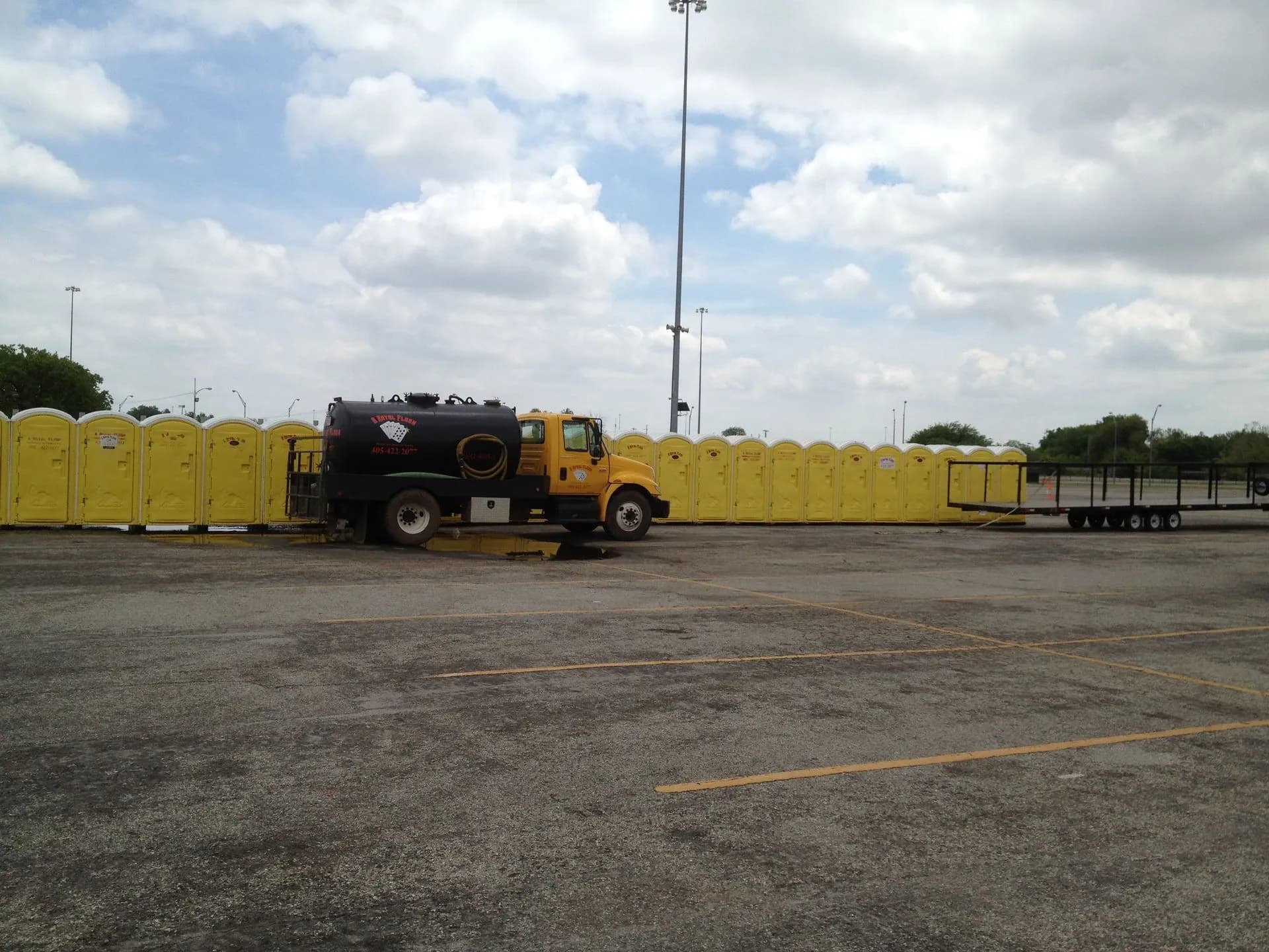 A Royal Flush pump truck and portable toilets deployed in a parking lot