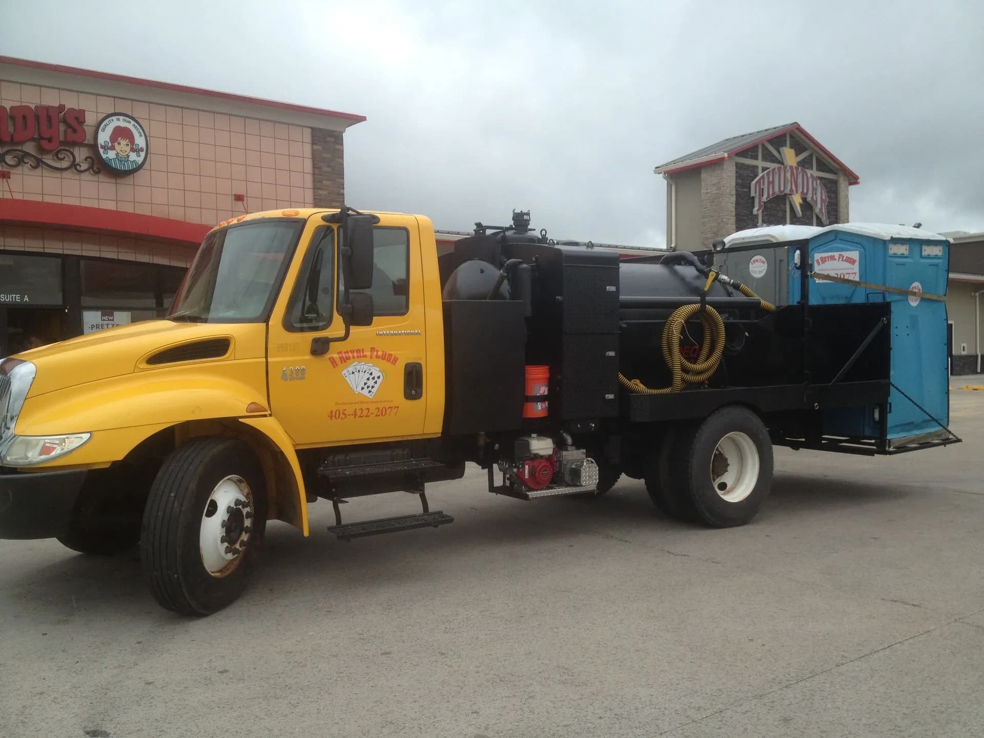 A Royal Flush septic pump truck outside a commercial building